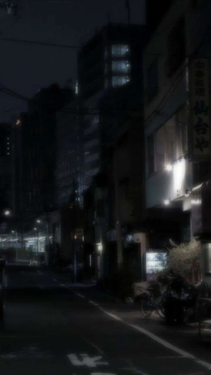 A street at night with buildings in the background
