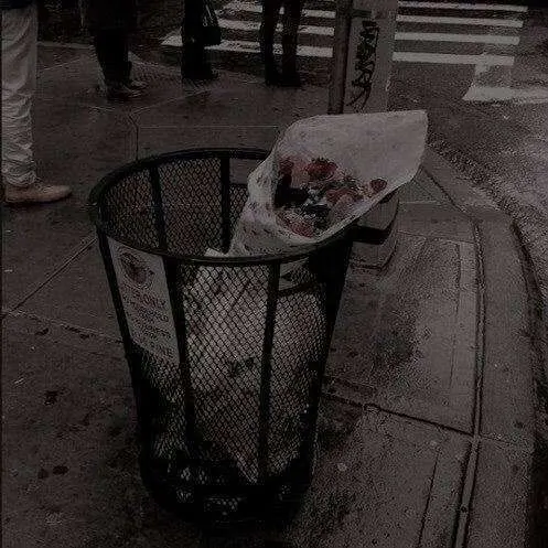A trash can on the sidewalk