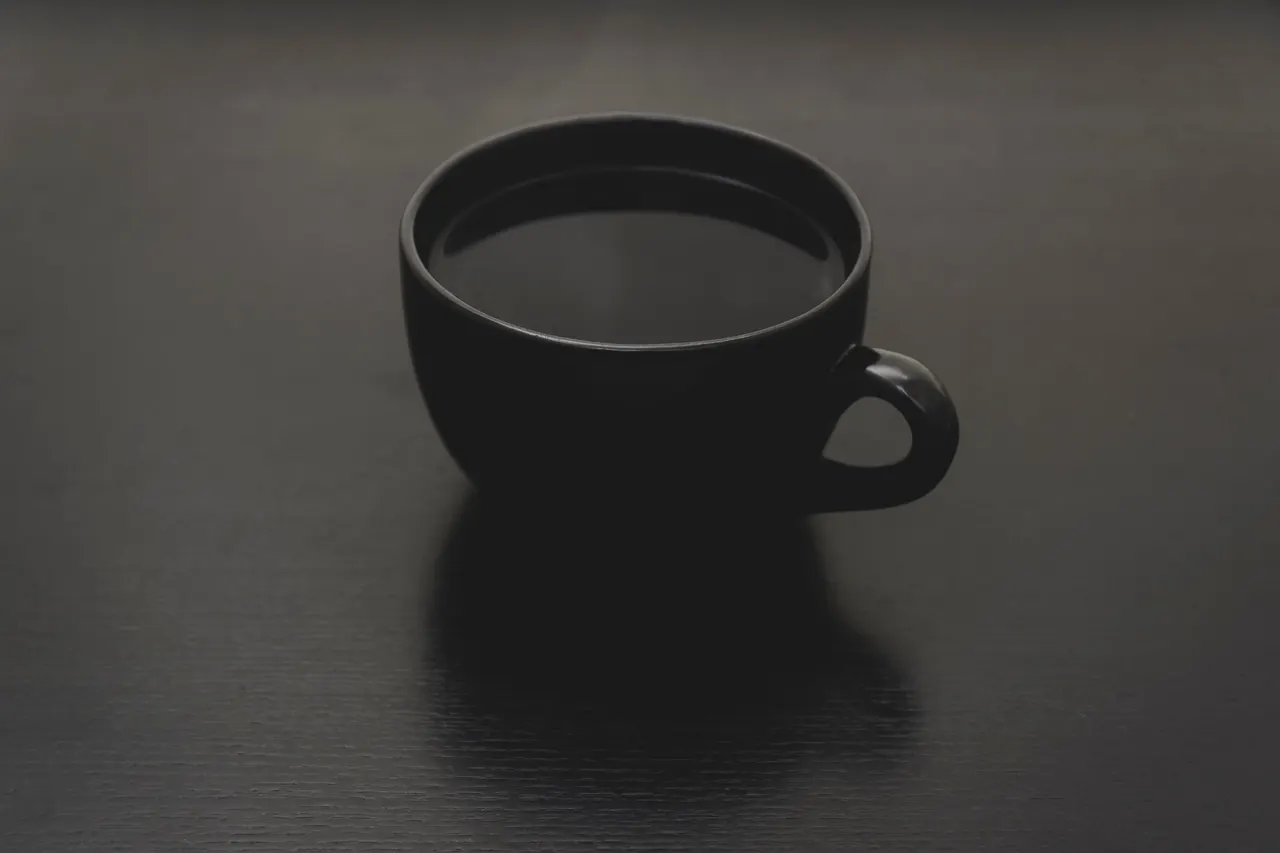 A black cup with liquid in it