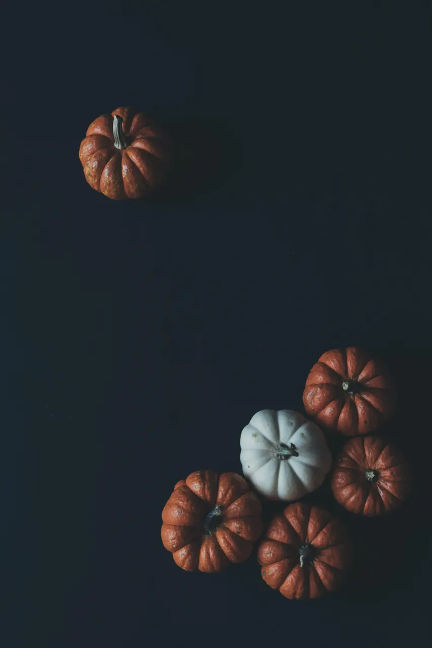 A group of pumpkins on a black surface