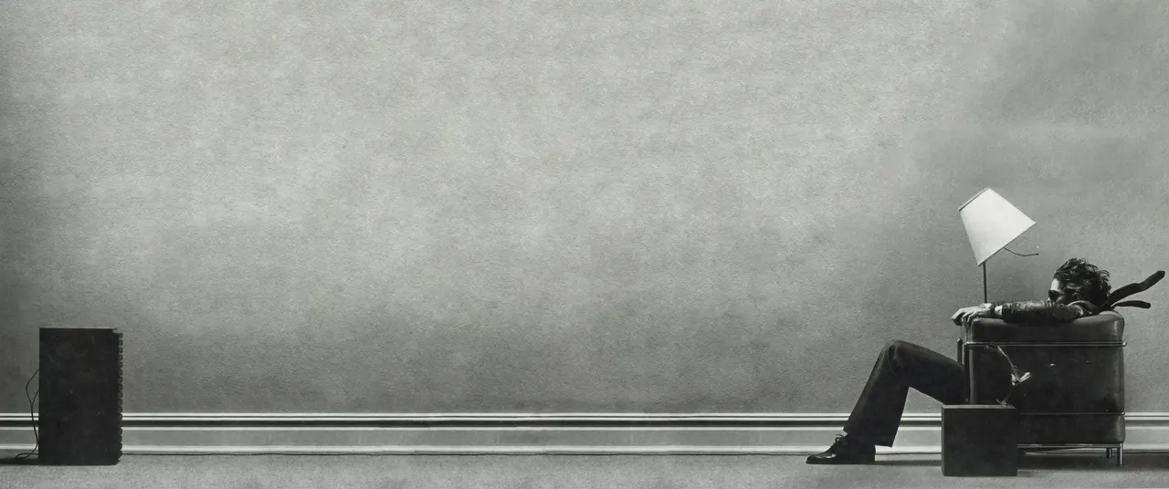 A man standing in a corner of a wall