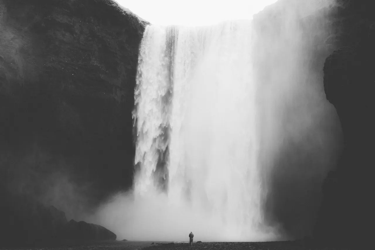 A person standing in front of a waterfall
