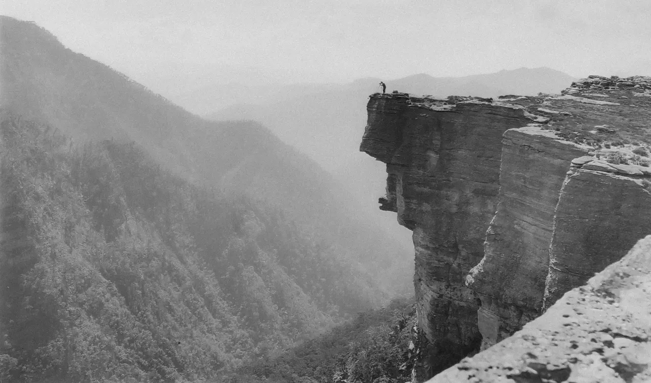 A person standing on a cliff edge
