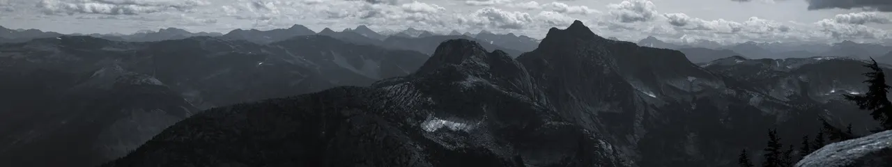 A mountain range with clouds in the background