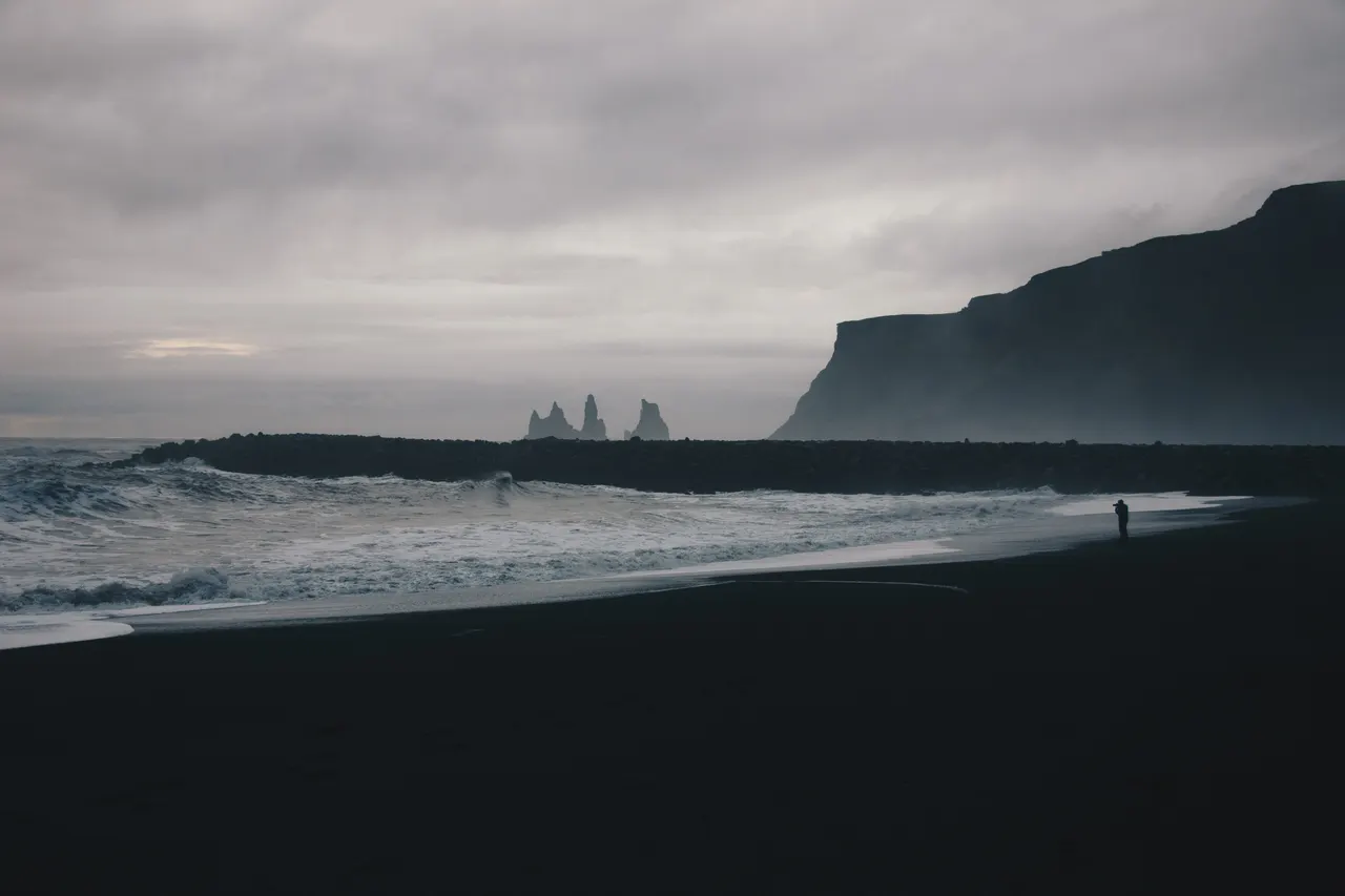 A beach with waves and cliffs