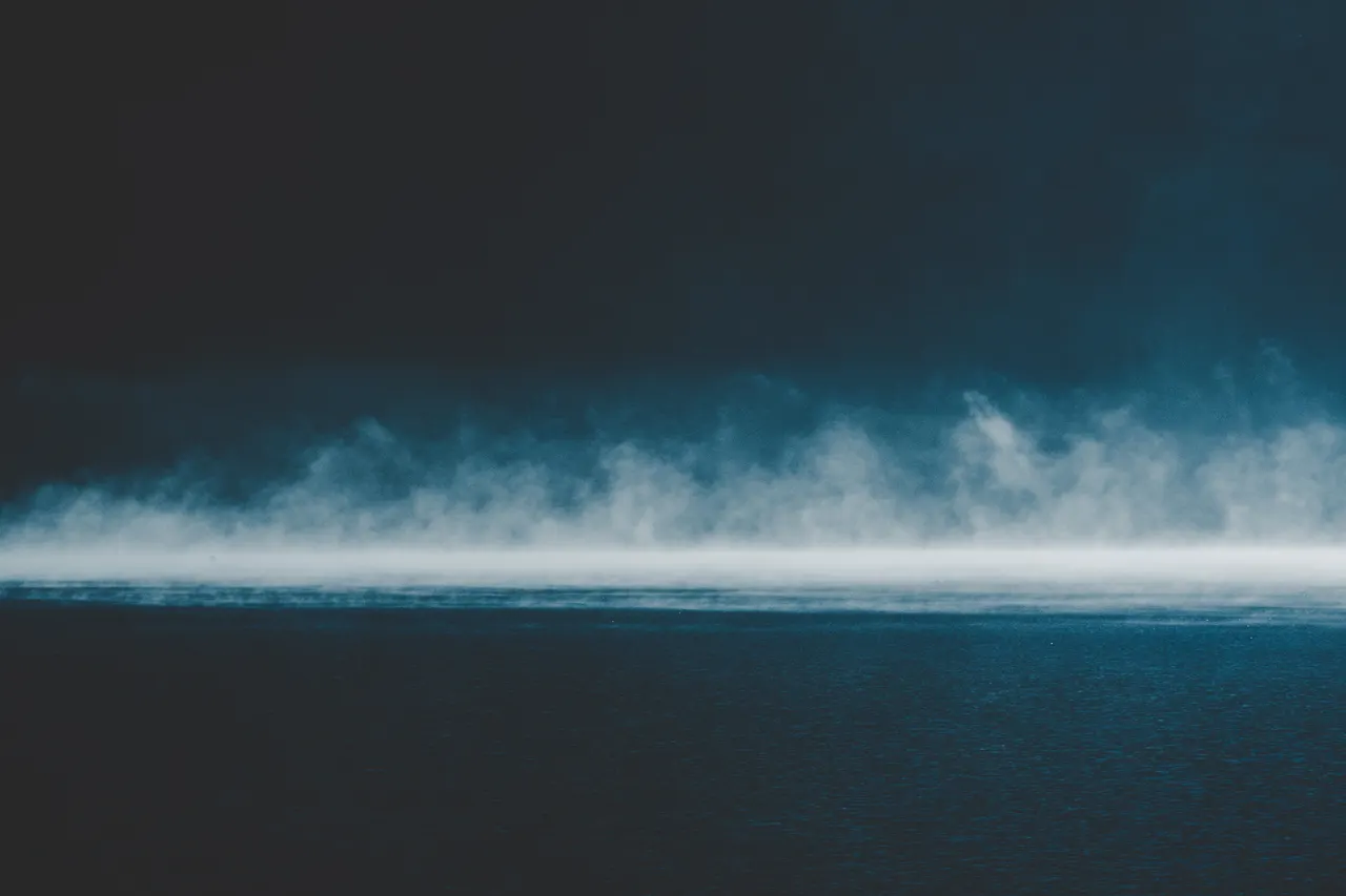 A fog over water with a black background