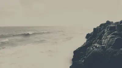 A person standing on a rocky cliff edge
