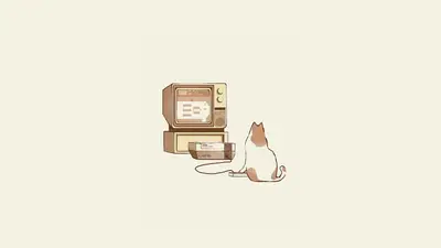 A cat sitting next to a computer