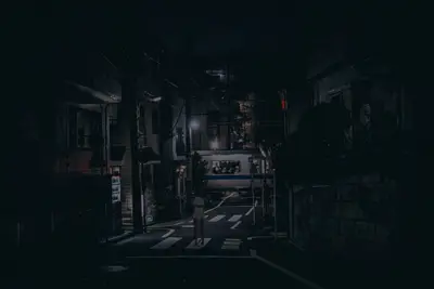 A person standing on a street at night