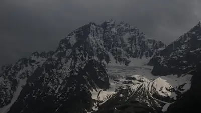A snowy mountain with dark clouds