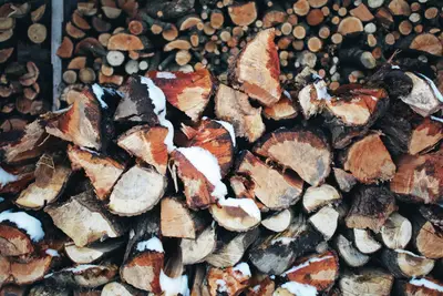 A pile of wood with snow on top