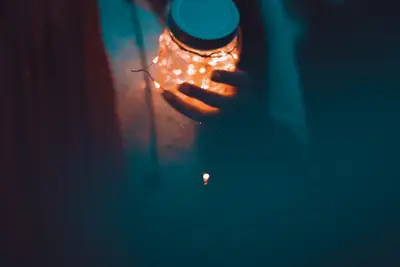 A person holding a jar with lights