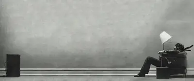 A man standing in a corner of a wall