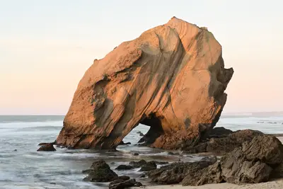 A large rock formation on a beach