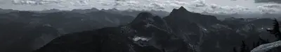 A mountain range with clouds in the background