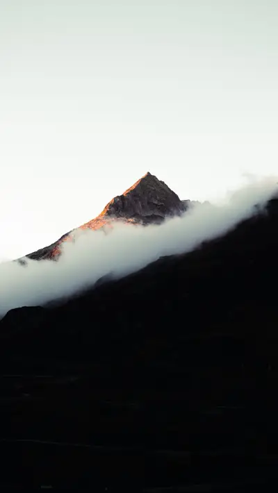 A mountain with clouds in the sky