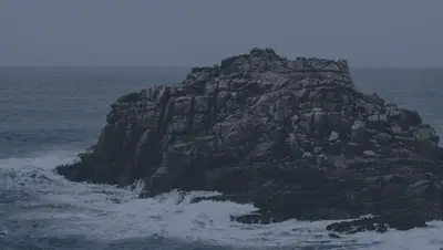 A rocky island with waves crashing on it