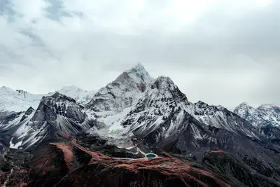 A snowy mountain with a lake in the middle