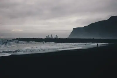 A beach with waves and cliffs