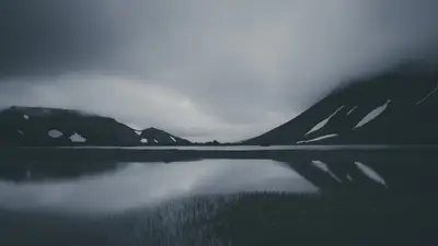 A lake with snow covered mountains in the background