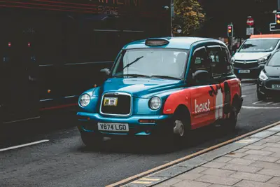 A blue and red taxi on the street