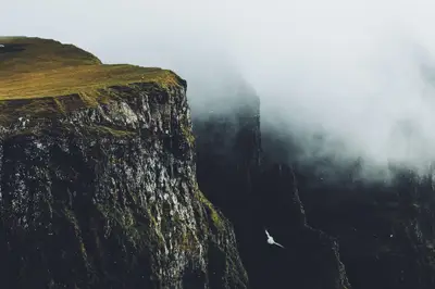 A cliff with fog and grass